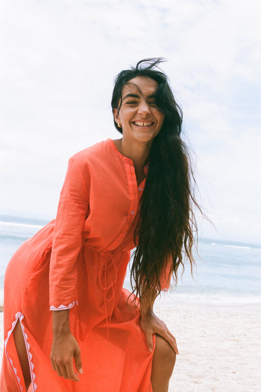 LILLY PILLY woman in a spritz Callie cotton dress standing on a beach